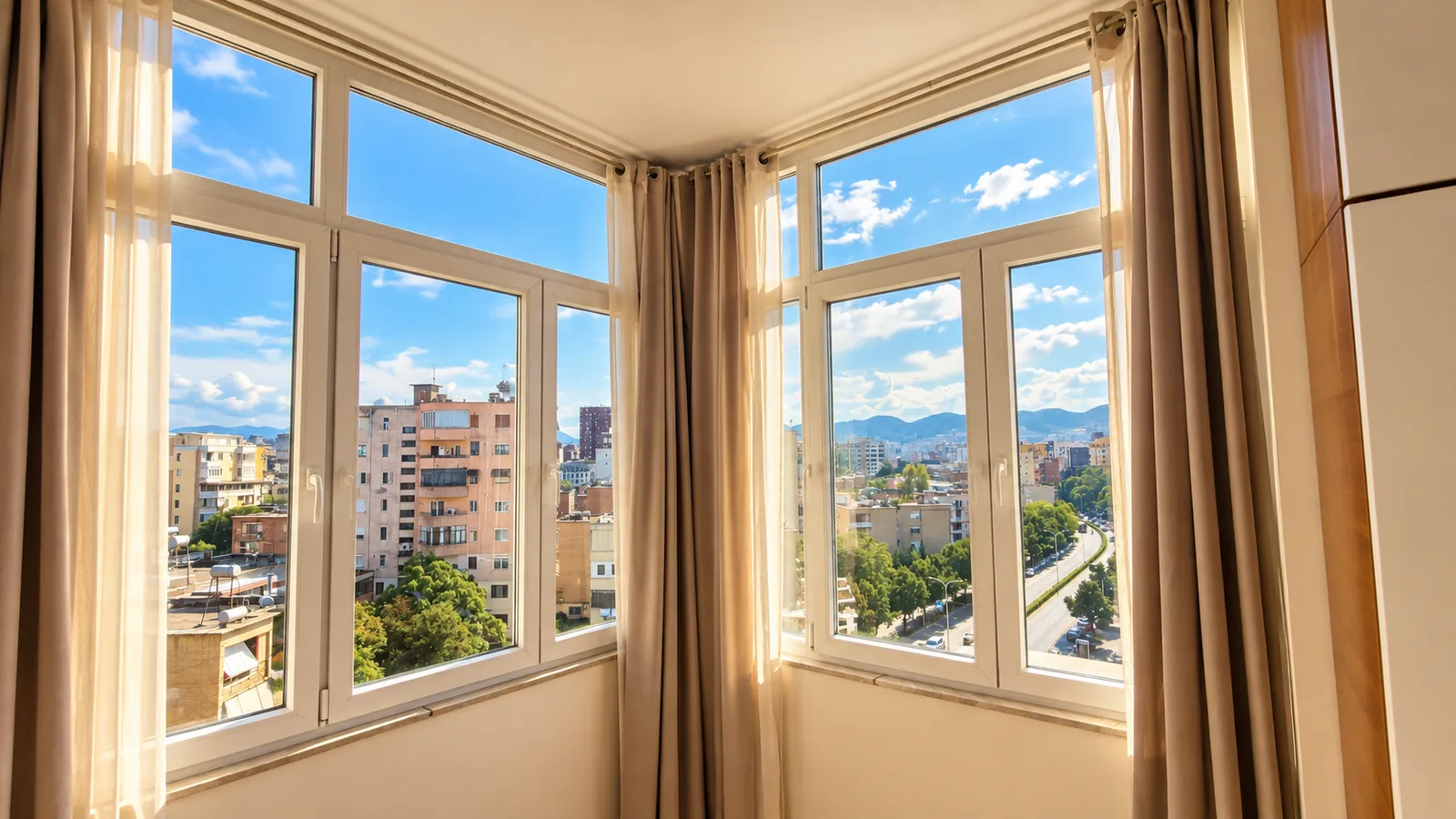 Corner bedroom windows overlooking Tirana and distant hills.